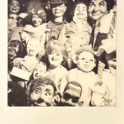 Black and white Polaroid close-up of vintage puppet and doll heads densely displayed together, showing various expressions and character types at Dreamfactory museum in Degersheim