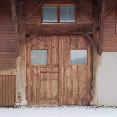 Aerial view of a traditional wooden chalet with a snow-covered roof and windows