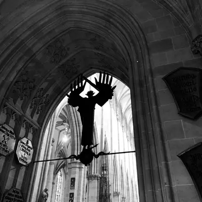 The interior of Ulm Cathedral. The massive figure of an angel armed with a sword under an arch in front of the building's interior.