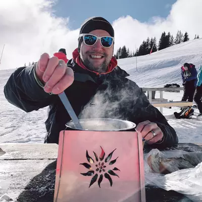 me eating a fondue by the side of the track with a broad smile.