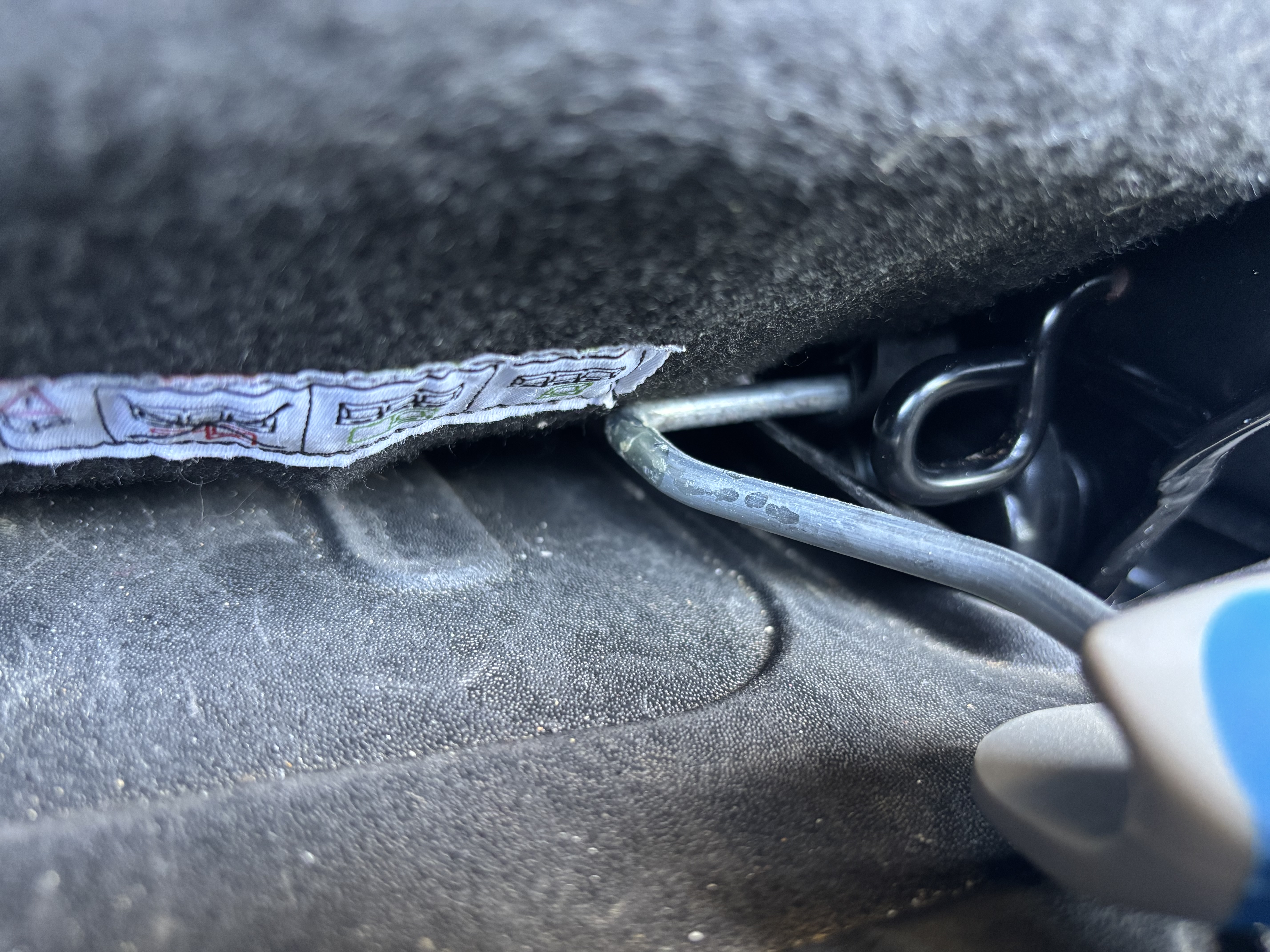 Le manche de rouleau de peinture est glissé dans les encoche du mécanisme de relevage du dossier.