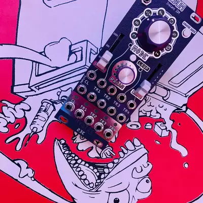A dark electronic music controller with illuminated knobs and buttons sits atop a vibrant comic-style illustration featuring bold red, pink, and purple colors with cartoon characters and dynamic linework.