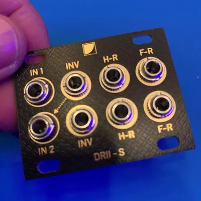 A black circuit board connector panel with eight gold-plated RCA junctions arranged in two columns, labeled IN 1, IN 2, INV (inverted), H-R (headphone right), F-R (front right), and DRII-S, with blue LED indicators illuminated inside each connector ring.