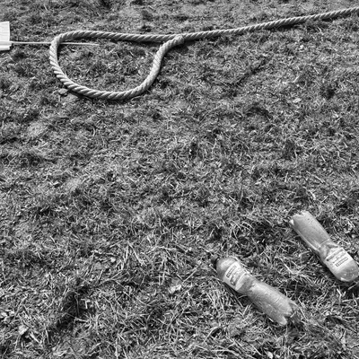 A rope and water bottles in the grass