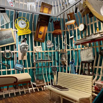 Colorful museum display at Lake Geneva Museum featuring nautical artifacts, clocks, and maritime equipment arranged on turquoise wooden slats