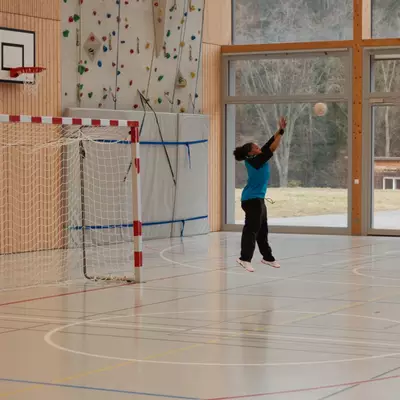 Gardienne du HBC Moudon en maillot bleu relançant le ballon depuis sa zone de but