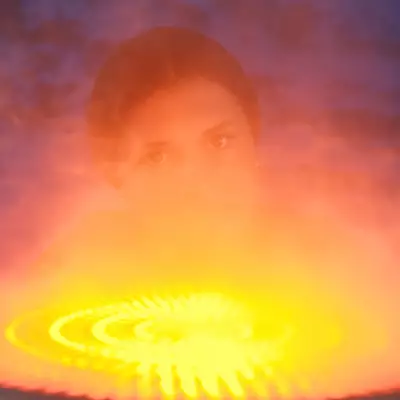 A child's face emerging from swirling orange and yellow mist, lit from below by a glowing spiral of light.