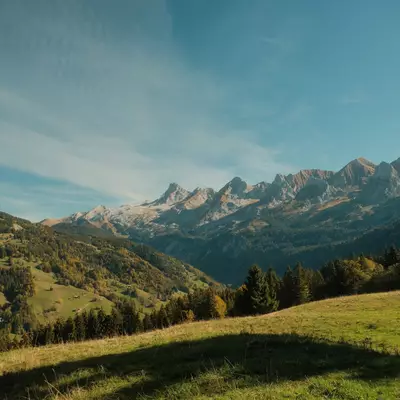 View of the rocky Alpine peaks from a lush green meadow, near La Clusaz in Haute-Savoie.