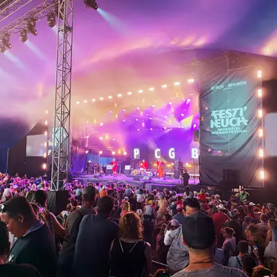 les petits chanteurs à la gueule de bois sur scène habillés d'un costume rouge et de chaussures bleues.