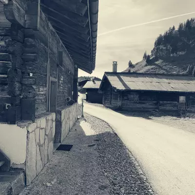 Black and white photo of châlets at Col de Bretaye. A path passes between the châlets