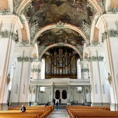 The interior of the monastery's abbey church. The decoration is very busy. The photo is taken from the central aisle.