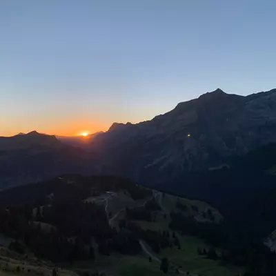 Le soleil se lève derrière les montagne. Au premier plan en contre-bas, la station superieur du télécabine du Meilleret