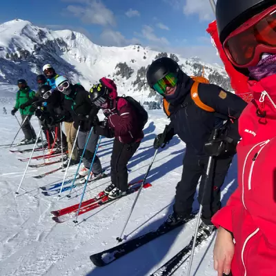 Yann, Christophe, Pierre-Yves, Vania, Natacha, Annick, Cédric and Céline pose in ski gear at the top of the slopes.